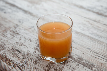 Glass of freshly pressed orange juice on wooden table