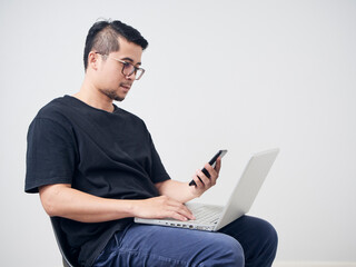 Man works with smartphone and laptop.