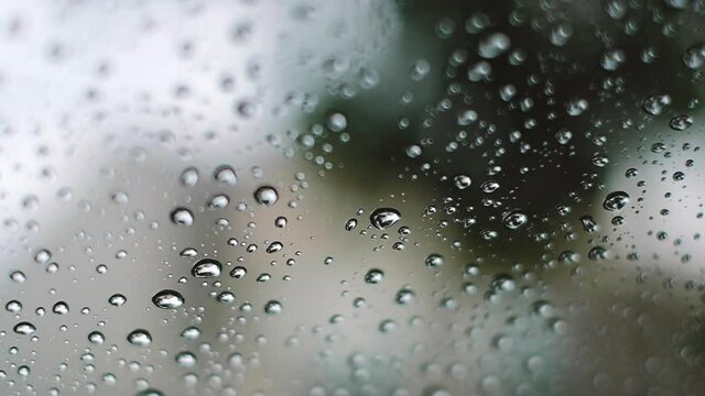  Rain on glass of window  outside. Closeup. Slow motion. Rain on the glass. Rain drops water on car window background. Slow 120 Flame/sec