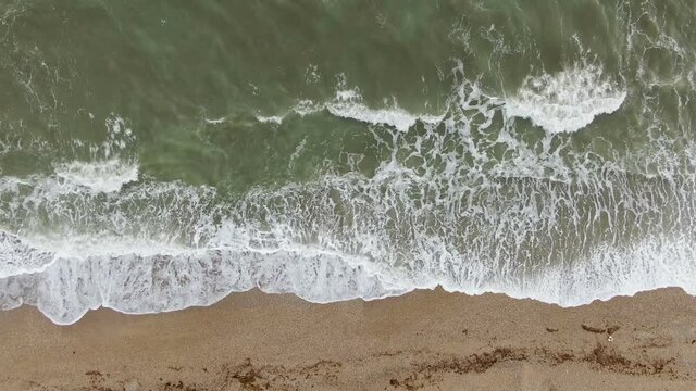 View from above on the sea surf on a sandy beach
