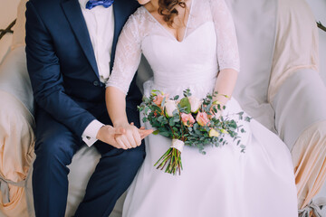 Wedding bouquet in the hands of the bride and groom
