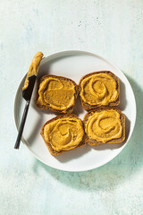 peanut butter spread on bread and a knife on a plate on the table