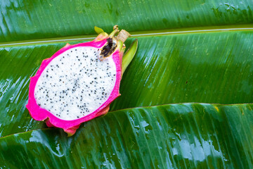 Ripe dragon fruit on a wet green leaf. Vitamins, fruits, healthy foods
