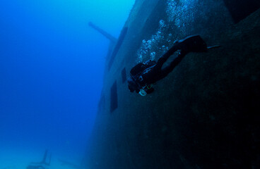 Shipwreck and scuba divers in the sea.
