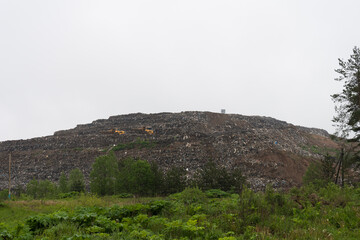 A huge landfill. Special cars drive on the mountain of garbage. Environmental pollution. Environmental disaster.