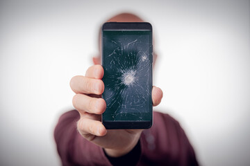 Zerstörtes Handy wird in Hand gehalten