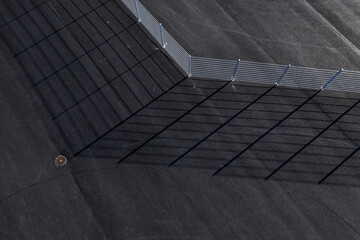Fototapeta premium Aerial view of a fence on asphalt and shadow.