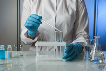 scientist’s hands are conducting chemical experiments in the laboratory. conceptual photo of...