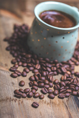 coffee cup and coffee beans on old wooden table. Vintage style