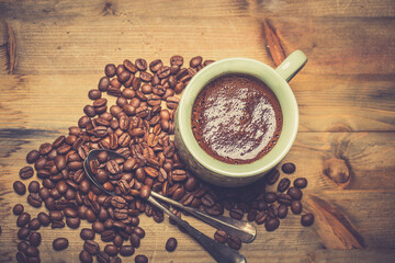 coffee cup and coffee beans on old wooden table. Vintage style