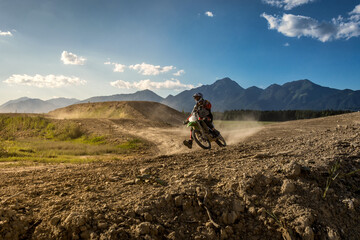 Extreme motocross on motocross track with Alps mountains in distance. Dirt track on a sunny late...
