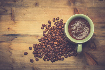 coffee cup and coffee beans on old wooden table. Vintage style