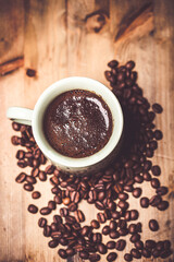 coffee cup and coffee beans on old wooden table. Vintage style