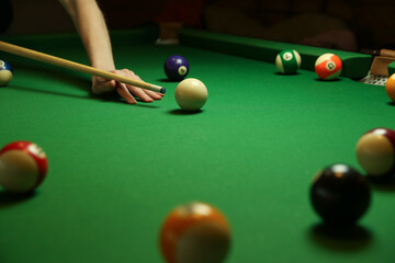 billiard background with color pool balls and cues on green table