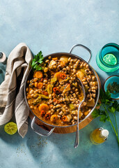 Black-eyed Pea Vegan Chili in a metal pan on a wooden stand on a blue background