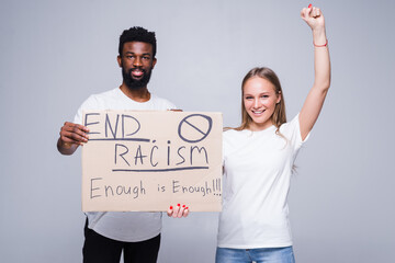 Young african man and coucasian woman holding a cardboard poster with the message text END RACISM isolated on white background, Concept on the theme of protest for police brutality and racism.