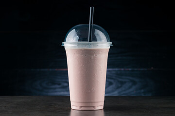 chocolate milkshake in plastic glass on a dark background. chocolate milkshake in takeaway cup