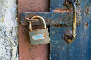 Old padlock on a rusty blue door