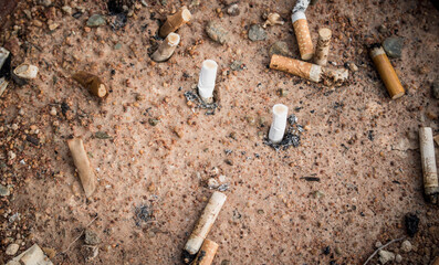 Cigarette butts in yellow sand. Problem of humanity. Cigarette smoking, bad habit. Nicotine addiction. Garbage. vintage style.