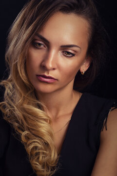 Delightful elegant young woman with long blonde hair in a black dress