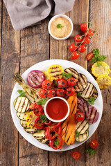 grilled colorful vegetable, bell pepper, zucchini, onion, tomato, carrot and dip sauce