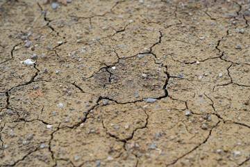 Closeup top view of arid land with broken dried soil surface