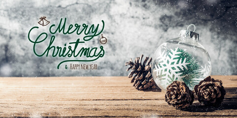 Fototapeta na wymiar Merry Christmas and happy new year sign with Christmas tree bauble and pine cone on wood table with concrete wall for celebrate holiday greeting card background
