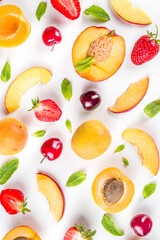 Summer background with fresh fruits and berries on white background. Set of various seasonal fruit and berry  - strawberry, apricots, peach slices, cherry, mint. Flat lay. Summer fruits concept.