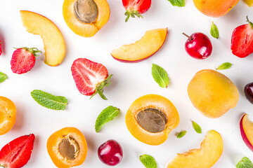 Summer background with fresh fruits and berries on white background. Set of various seasonal fruit and berry  - strawberry, apricots, peach slices, cherry, mint. Flat lay. Summer fruits concept.