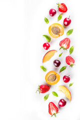 Summer background with fresh fruits and berries on white background. Set of various seasonal fruit and berry  - strawberry, apricots, peach slices, cherry, mint. Flat lay. Summer fruits concept.