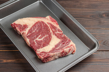 Raw meat. Marbled beef steak in metal baking dish.