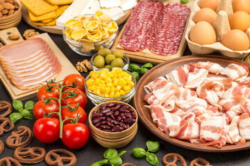 Bacon, sausages, cheese, vegetables, cookies, cereal eggs: ingredients for continental breakfast.