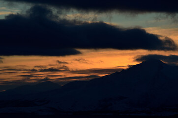 colorful dawn sky over snowy mountain and sea