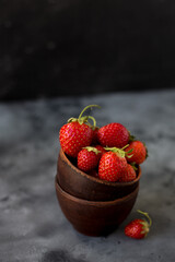 Bowls with ripe fresh strawberry on dark background