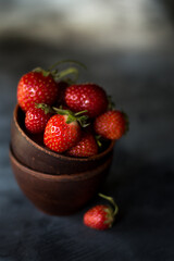 Bowls with ripe fresh strawberry on dark background