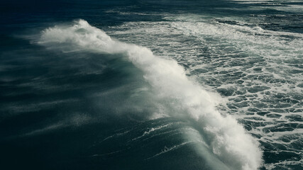 wind blowing over breaking wave