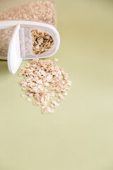 Plastic transparent container with oatmeal on a green background.