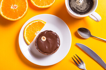 Chocolate tart, baked desert filling over a pastry base with nuts on yellow background