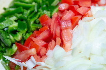 chopped peppers, tomatoes and onions on a table.