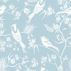 Seamless pattern in oriental style with blooming branches trees and birds. Wildlife silhouette, white floral ornament on blue background. Vector hand drawn illustration, garden in japanese style.