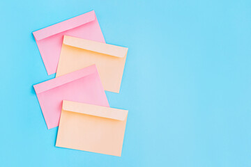 Colorful correspondence envelopes on blue background with copy space.