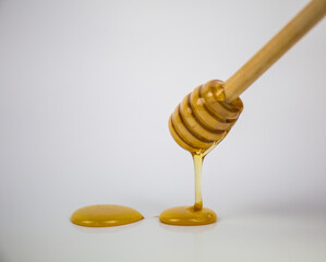 Honey dripping isolated on a white background. Natural remedy and prevention for diseases