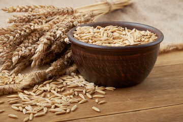 Уши пшеницы и чаша зерна пшеницы на коричневом...