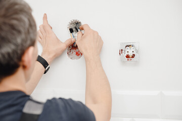 Sockets outlet install Electrician man builder working at home