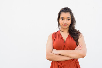 Young beautiful Indian woman with arms crossed against white background