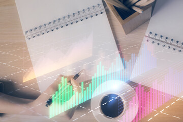 Multi exposure of woman's hands making notes with forex graph hologram. Concept of technical analysis.