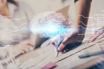 Double exposure of woman's writing hand on background with brain hud. Concept of learning.