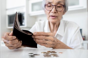 Female senior holding empty wallet,old people shaking out money coins in wallet,financial problems...