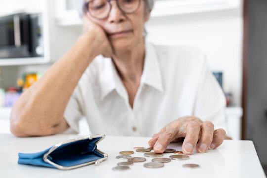 Stressed senior woman is counting remaining coins from pension,old elderly counting last money coins in her purse,financial problems,planning savings,no retirement savings,poverty, absence of money