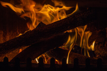 Horizontal view of roaring flames at a house fireplace.